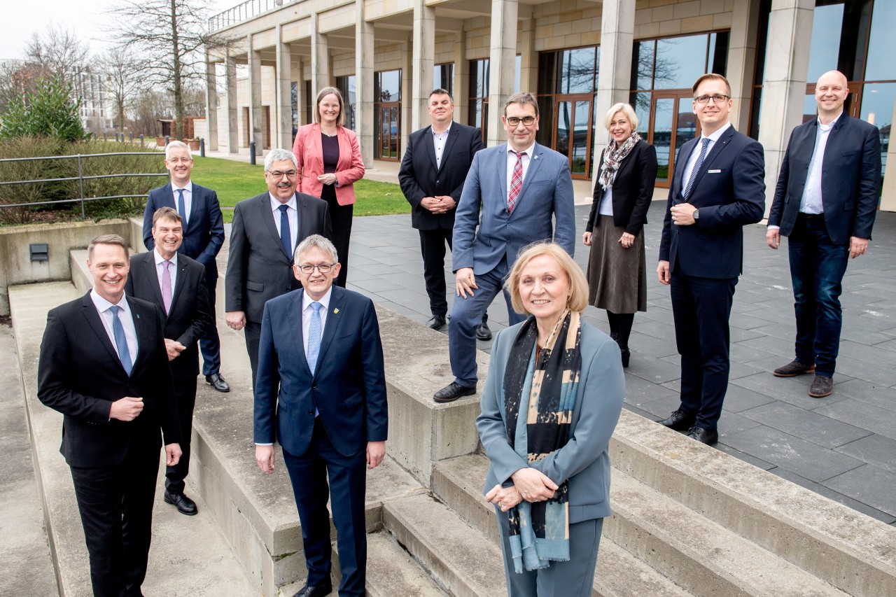 Die Teilnehmer stehen vor Beginn einer Pressekonferenz zur Gründung der Agentur vor dem Atlantic Hotel.