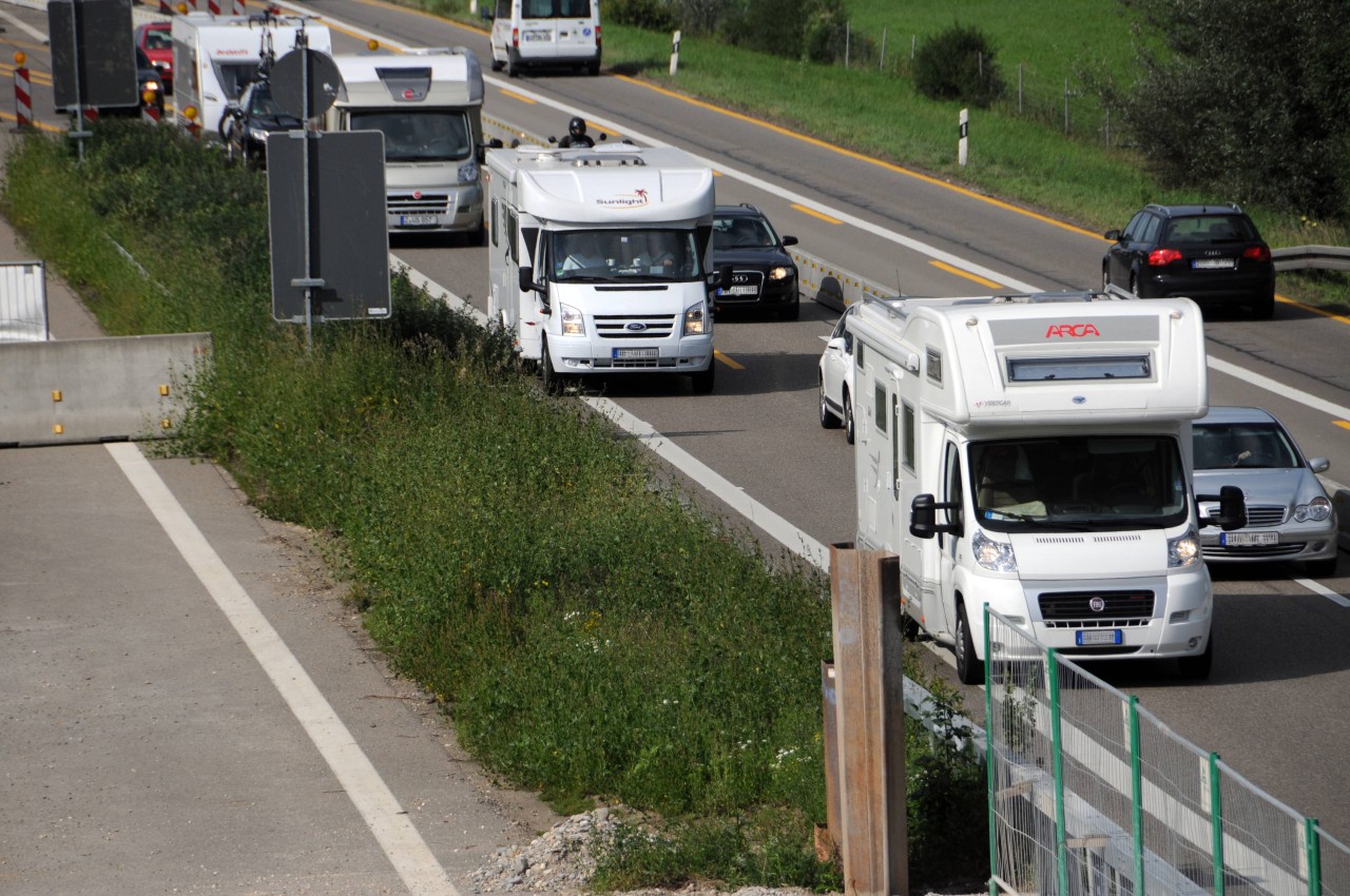 Camping-Wohnmobile im Treck auf einer Autobahn.