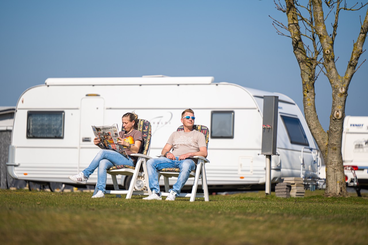 Ein Paar genießt die Sonne auf einem Camping-Platz an der Nordsee.