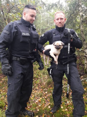 Polizisten mit dem geretteten Mops. 