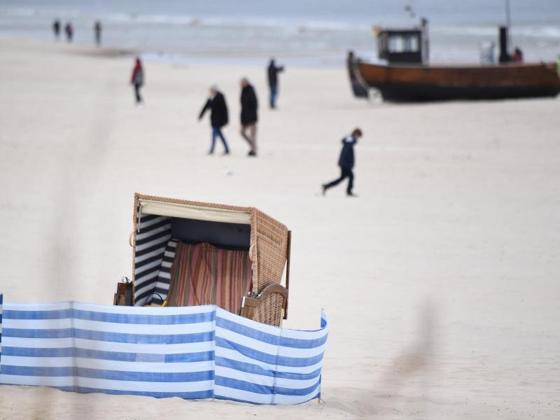 Spaziergänger sind an einem Strand auf Usedom unterwegs.