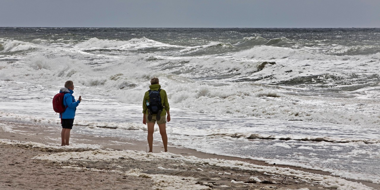 Menschen bei rauem Wetter am Strand auf Sylt