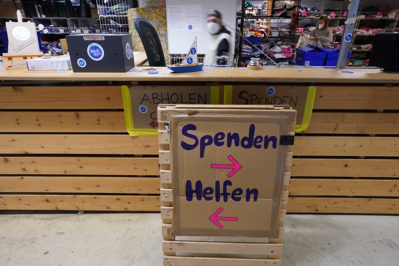 „Spenden, Helfen“ steht auf einem Aufsteller in der Kleiderkammer der Hilfsorganisation Hanseatic Help.